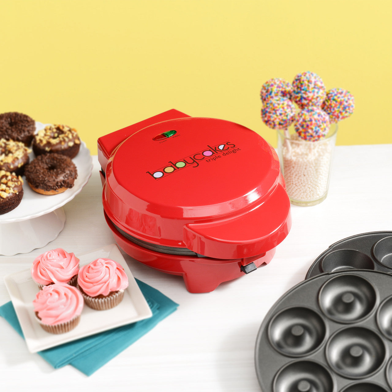 BabyCakes 3-in-1 multi plate treat maker red MT-6 lifestyle image with plated cupcakes, donuts and cake pops Select Brands